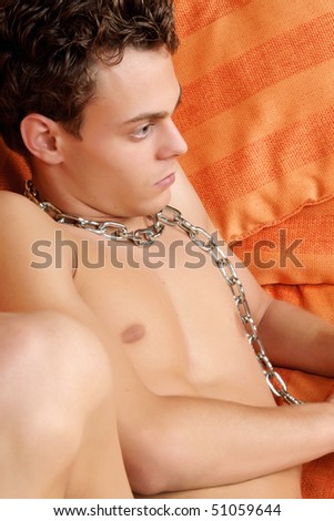 stock photo : Sexy young man with blue eyes and brown hair with a chain 