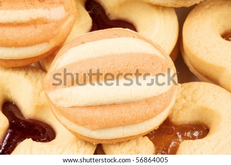 Closeup of some mixed shortcrust pastry biscuits with apricot and plum jam.