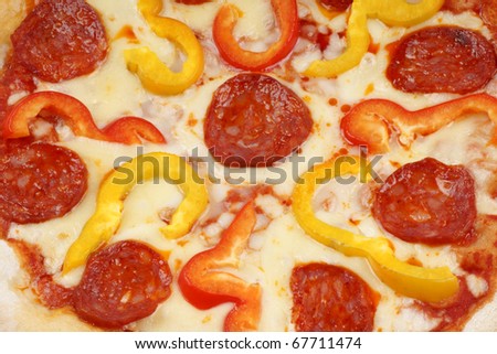 Full frame of original italian pizza with mozzarella tomato, hot spicy salami and red and yellow bell peppers.