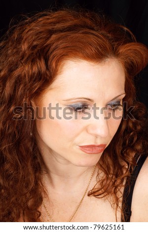 Portrait of a caucasian woman with red hair and brown eyes. Over a black background.