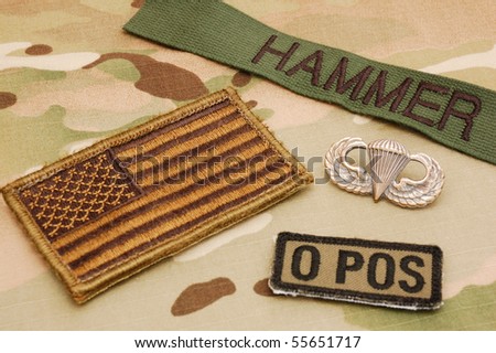 US flag, name tag, blood type patch and jump wings on multicam camo background