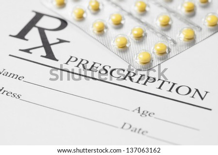 Medical stuff - blank prescription and pills on table