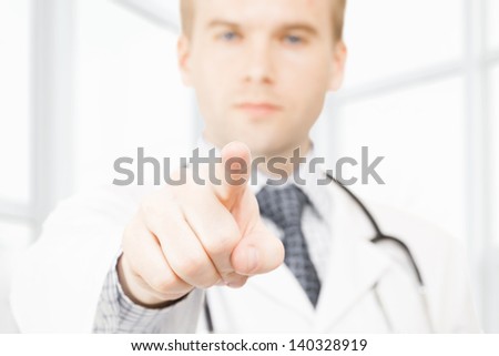 Male doctor pointing his index finger toward viewer