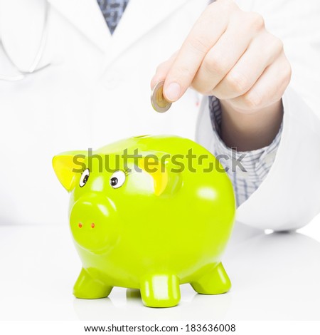 Medical doctor putting a coin into piggy bank as an idea for healthcare insurance and savings for medical expenses - 1 to 1 ratio