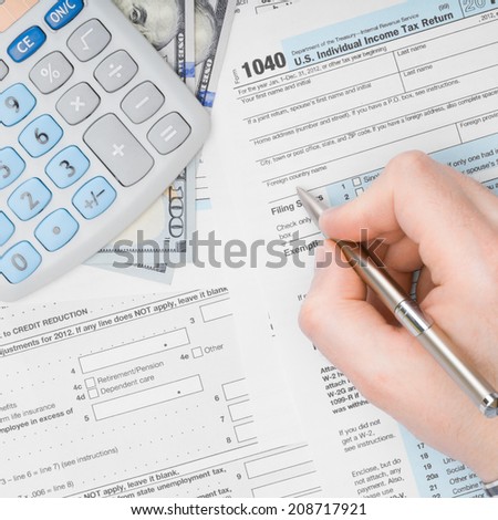 Man filling out 1040 US Tax Form - view from top - 1 to 1 ratio