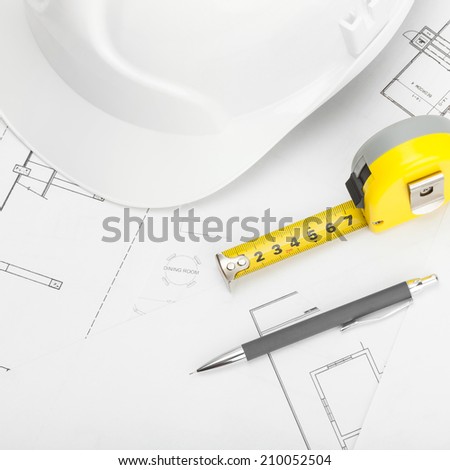 White construction helmet with pencil and measure tape over some documents - 1 to 1 ratio