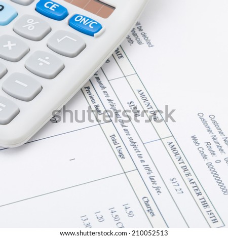 Studio shot of utility bill next to calculator - 1 to 1 ratio