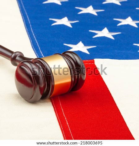 Wooden judge gavel over US flag - closeup studio shot - 1 to 1 ratio