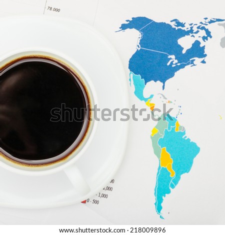 Coffee cup over world map and financial documents - view from top - 1 to 1 ratio