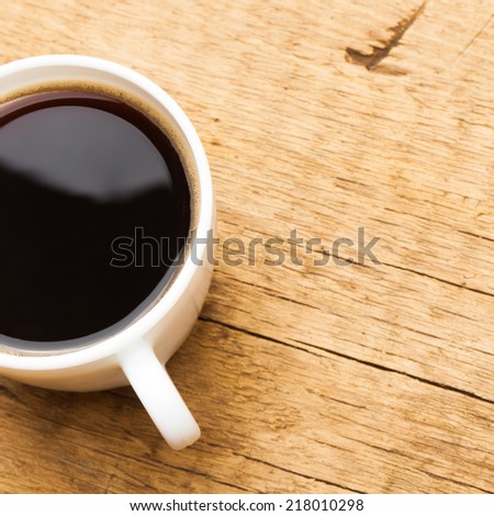 Coffee in white ceramic cup on wooden table - view from top - 1 to 1 ratio