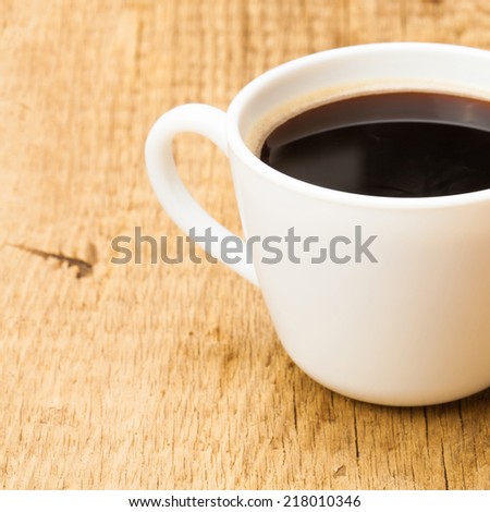Black coffee in white ceramic cup on wooden table - studio shoot - 1 to 1 ratio