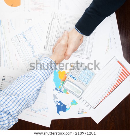 Business people shaking hands over table - view from top - 1 to 1 ratio