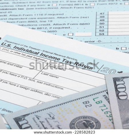 US Tax Form 1040 with 100 US dollar bills