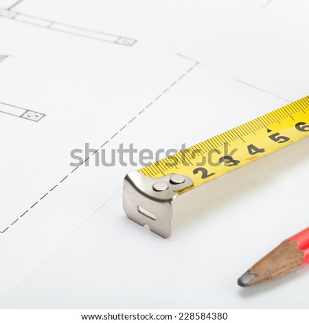 Measure tape and pencil over some documents