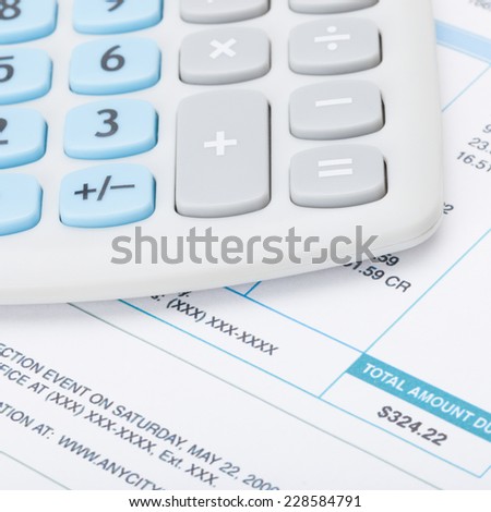 Neat calculator over utility bill - studio shot