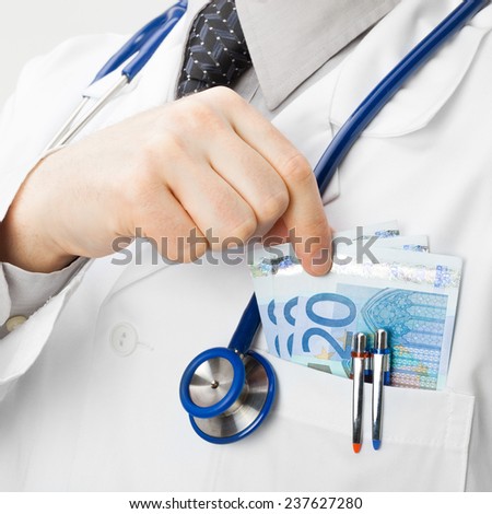 Doctor with money in his pocket - health care concept