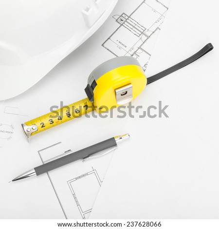 Construction helmet with pencil and measure tape - construction industry concept