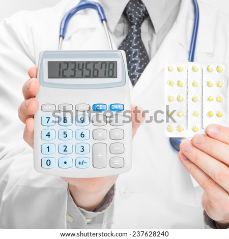 Doctor holdling calculator and pills in his hands - medical aid concept
