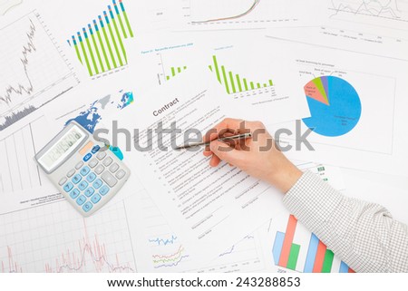 Male hand and financial charts and graphs