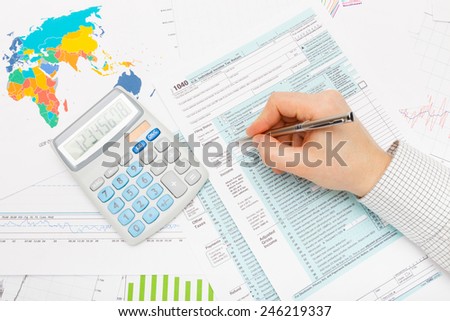 Male filling out 1040 US Tax Form with silver pen