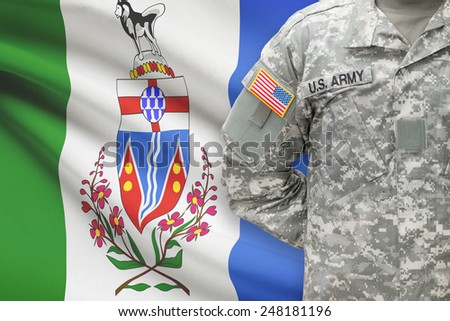 American soldier with Canadian province flag on background - Yukon