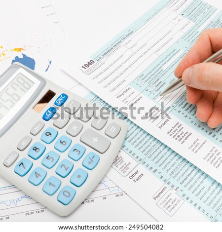 Male filling out US 1040 Tax Form - studio shot