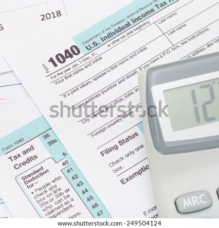 Calculator over US 1040 Tax Form - studio shot