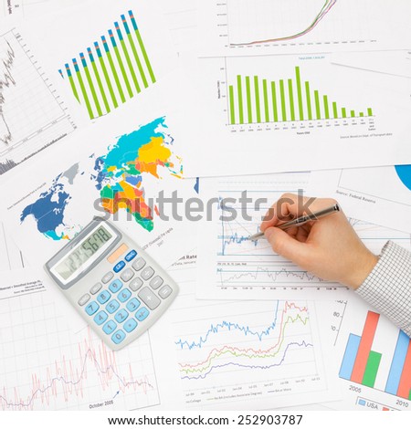 Business man and financial data - pen in hand