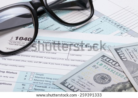 US 1040 Tax Form, glasses and dollars - studio shot