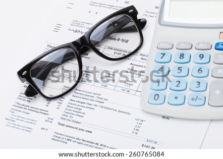 Calculator and glasses with utility bill under it - studio shot