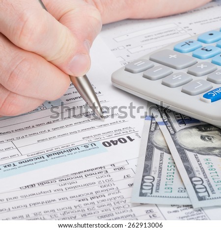 Taxpayer filling out USA 1040 Tax Form - studio shot