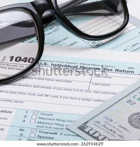 US 1040 Tax Form, glasses and dollars - studio shot