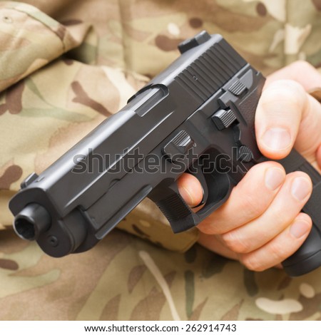 Man in black mask holding gun behind his back