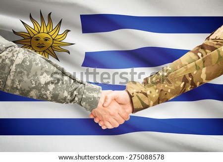 Soldiers shaking hands with flag on background - Uruguay