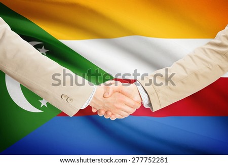 Businessmen shaking hands with flag on background - Comoros