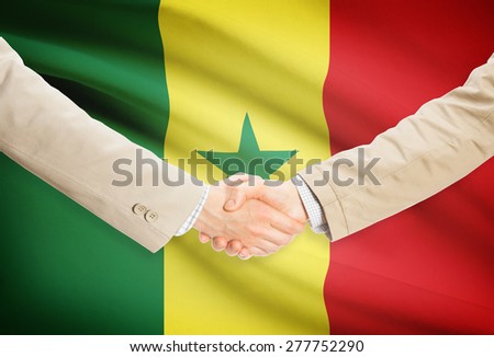 Businessmen shaking hands with flag on background - Senegal