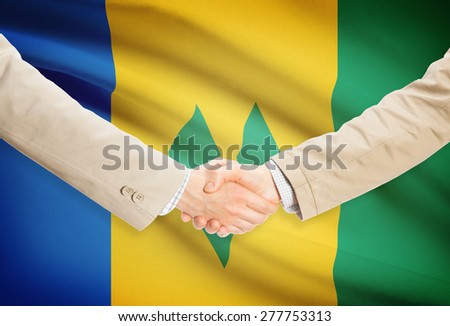 Businessmen shaking hands with flag on background - Saint Vincent and the Grenadines