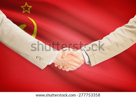 Businessmen shaking hands with flag on background - USSR - Soviet Union