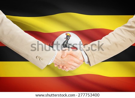 Businessmen shaking hands with flag on background - Uganda