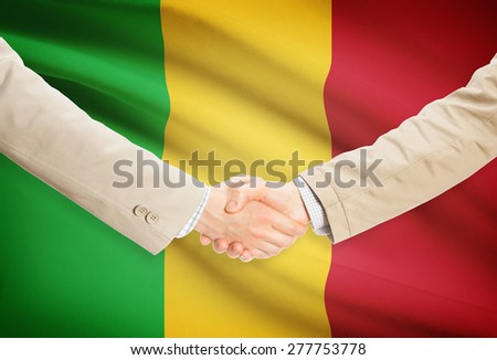 Businessmen shaking hands with flag on background - Mali