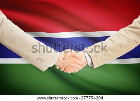 Businessmen shaking hands with flag on background - Gambia