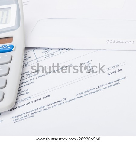 Calculator with utility bill under it - close up studio shot