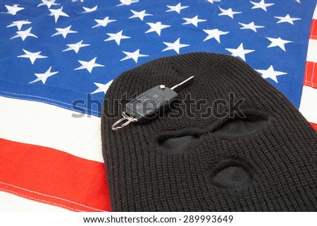 Thief mask with car keys over US flag - studio shot