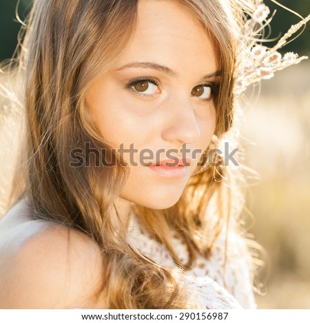 Portrait of young beautiful model in open field at sunrise - outdoors shot