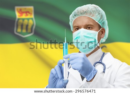 Doctor with syringe in hands and Canadian province flag on background - Saskatchewan