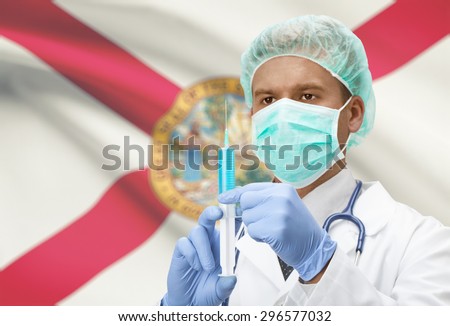 Doctor with syringe in hands and USA states flags on background - Florida