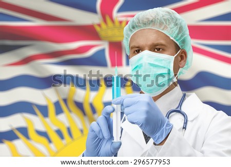 Doctor with syringe in hands and Canadian province flag on background - British Columbia