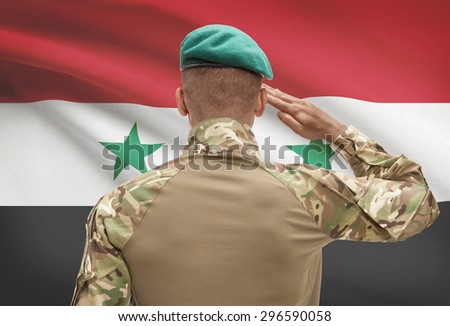 Dark-skinned soldier in hat facing national flag series - Syria