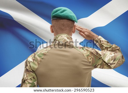 Dark-skinned soldier in hat facing national flag series - Scotland