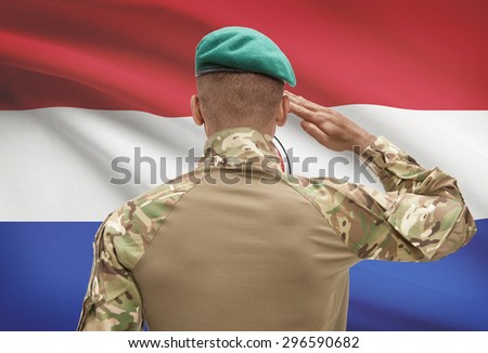 Dark-skinned soldier in hat facing national flag series - Paraguay